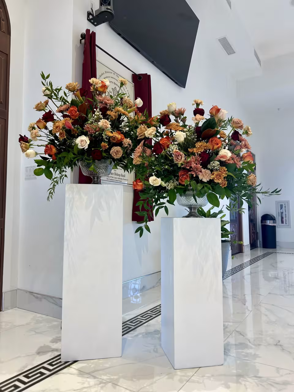 Two pedestal arrangements in a church entry, autumn palette